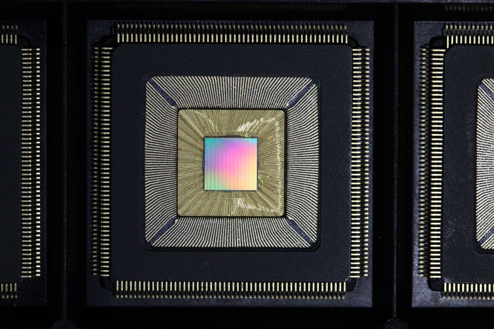 The Princeton Piton Processor is shown without its protective lid. Multicolored silicon die is bonded to wires inside the chip package.