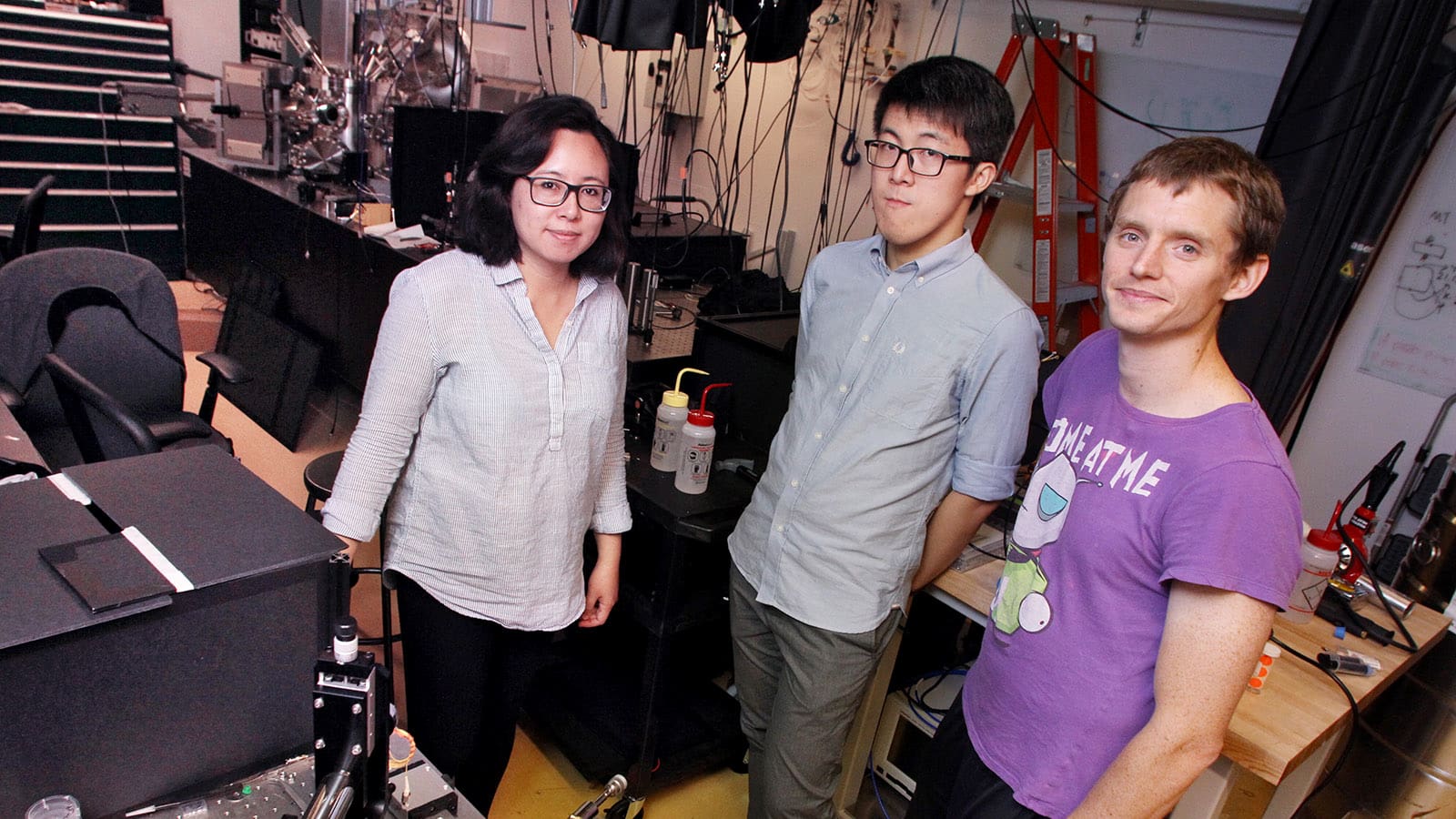Professor, graduate student and postdoc stand in lab