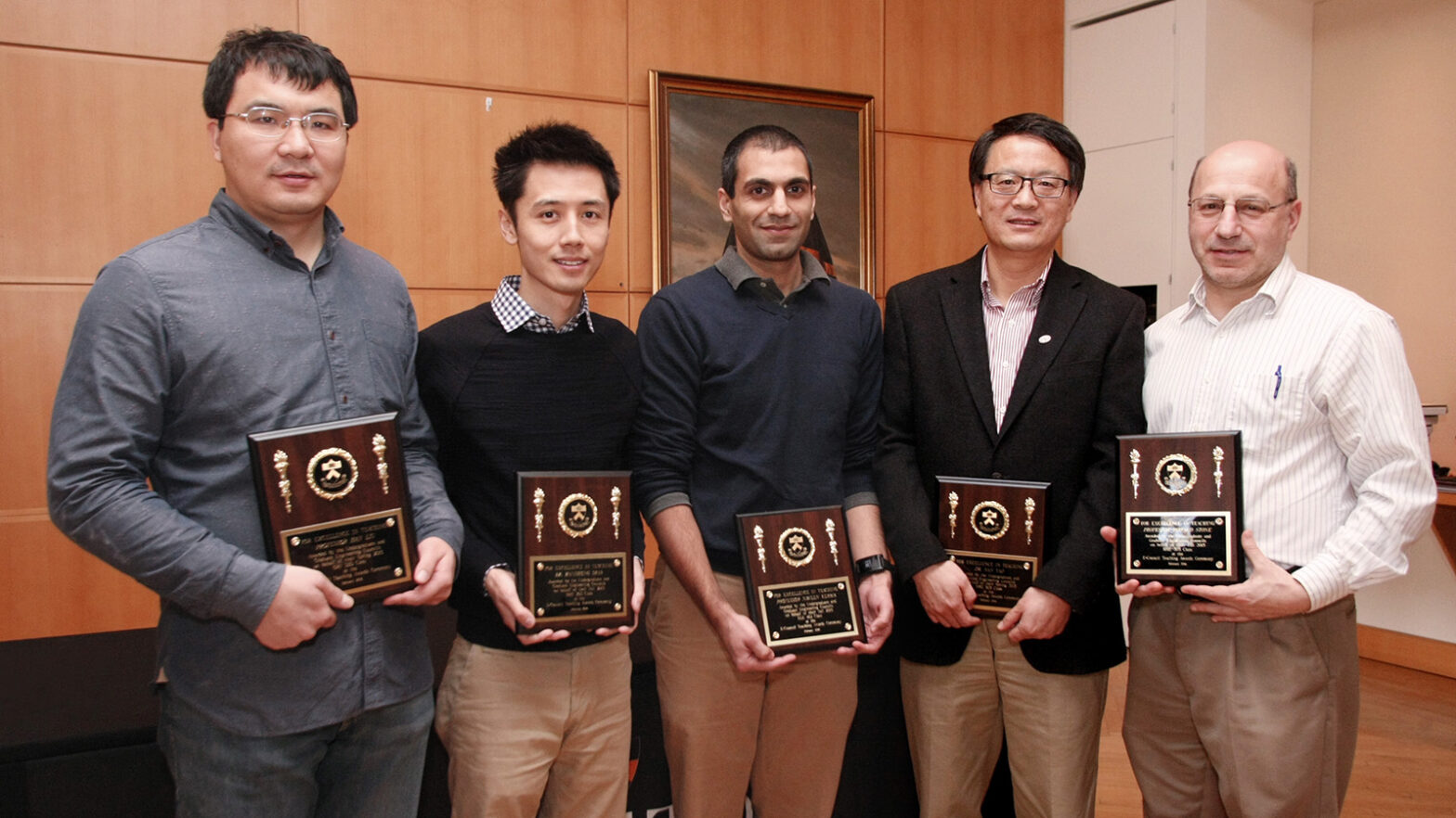 Five faculty members pose with teaching awards