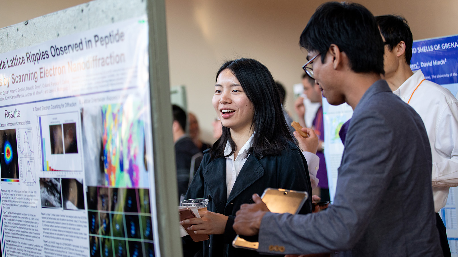 Graduate students discuss research at conference poster session
