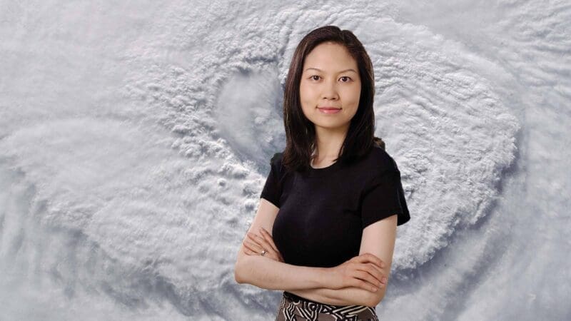 Photo of Ning Lin, with image of hurricane cloud formation behind her.