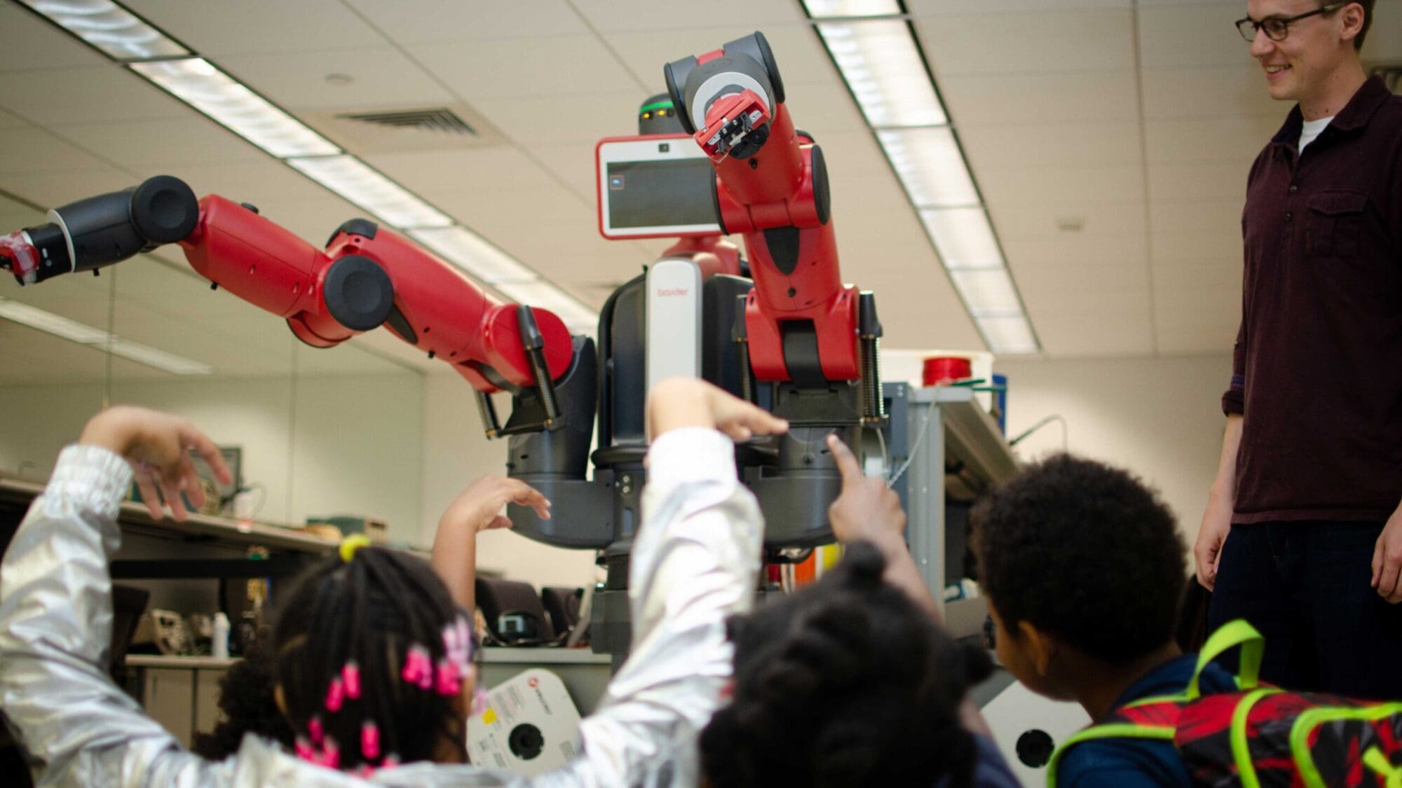 Elementary schoolers moving arms along with educational robot