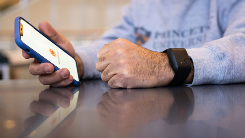 Hands holding smartphone and wearing smartwatch