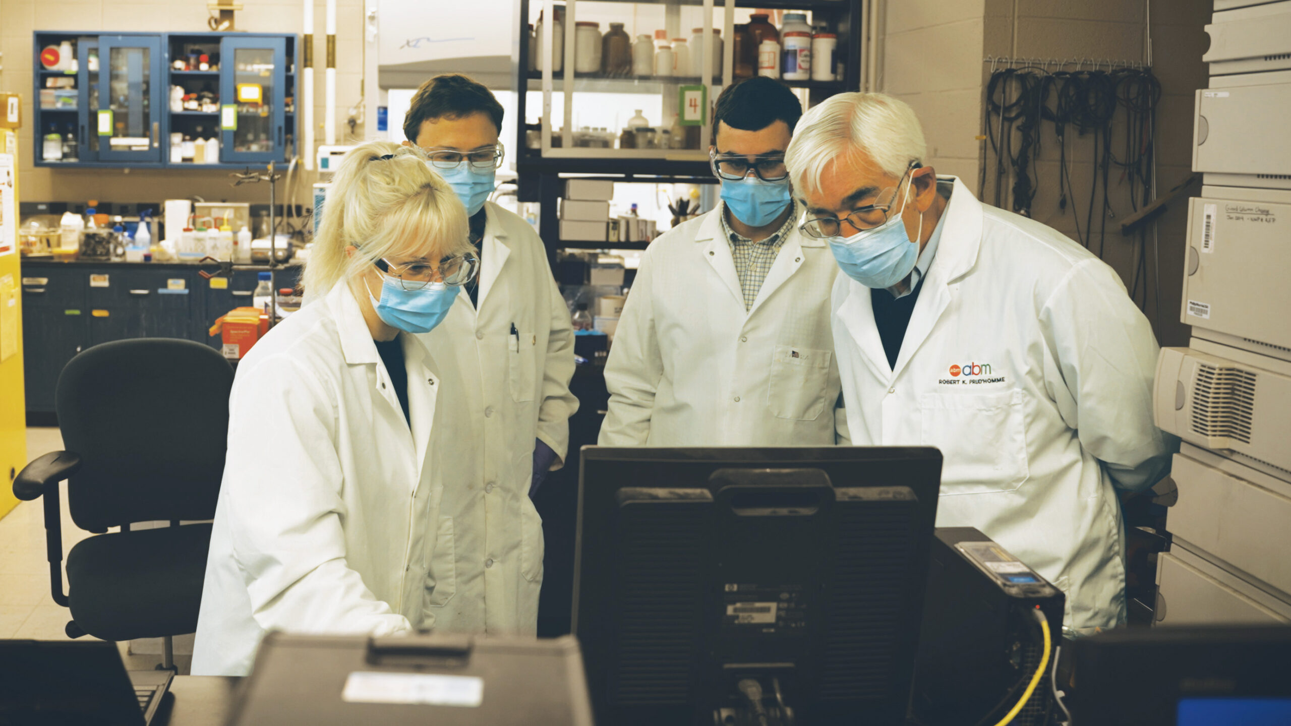 four researchers gather around a screen in a lab