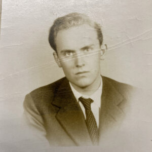 Old black and white male student portrait, with crease