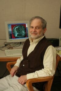Ken Steiglitz sitting in front of a 2000's-era computer