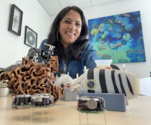 Portrait of researcher with small robots on table