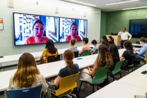 Woman speaks to class over teleconference