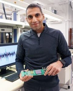 Verma in his lab holding a prototype of the chip on a board