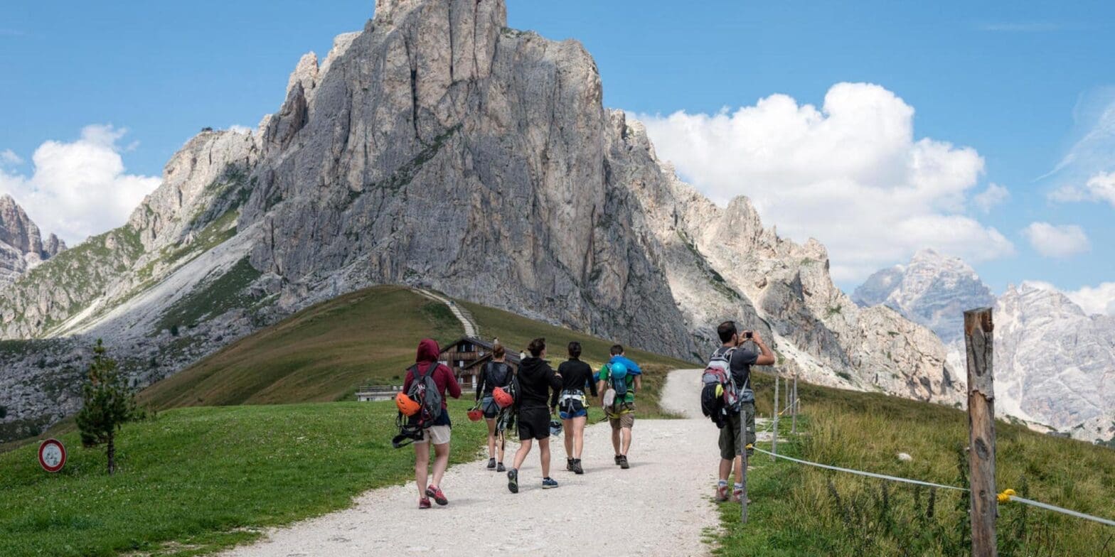 students hiking towards mountain during spring in europe