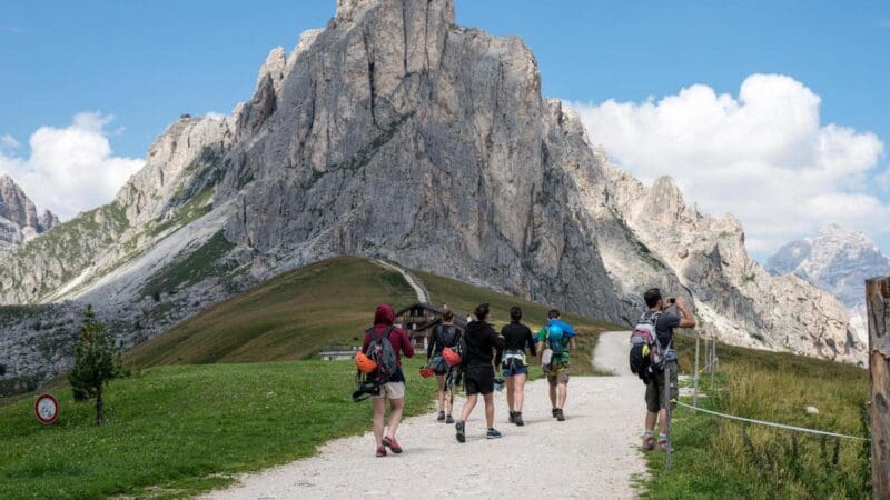 students hiking towards mountain during spring in europe