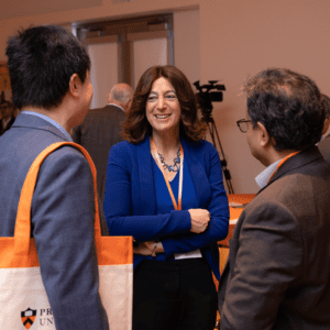 tech leader and engineering dean Andrea Goldsmith, talks casually to two conference attendees from industry.