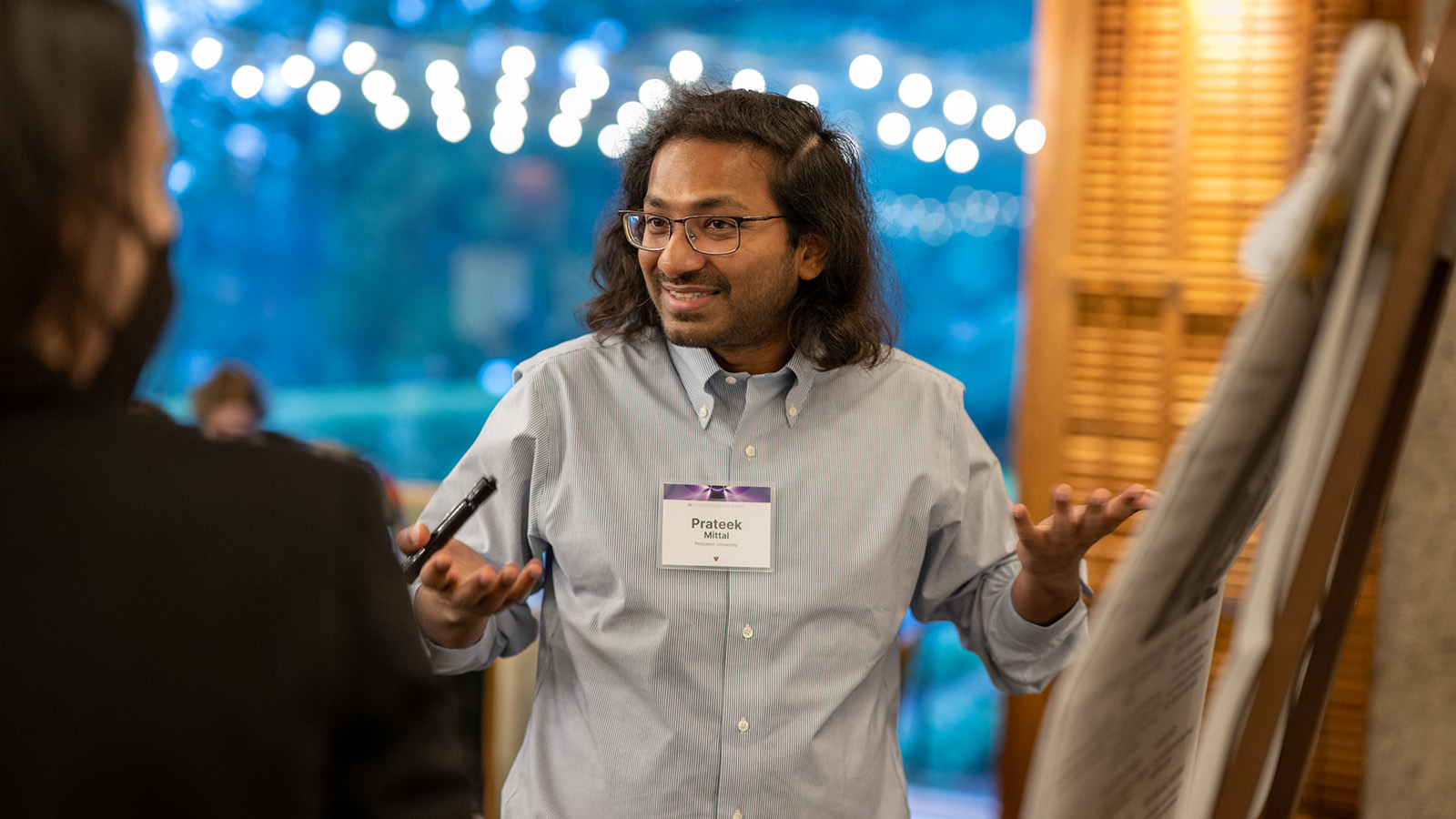 Prateek Mittal talks with colleagues at a conference.