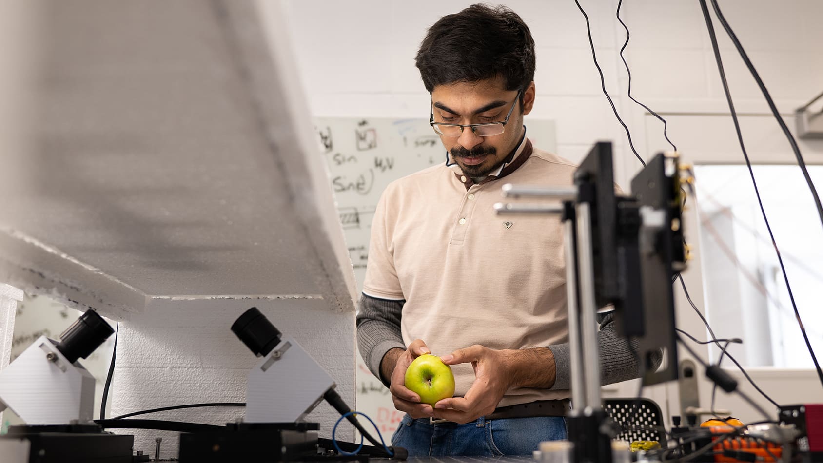 Researcher examines a green apple in the lab.