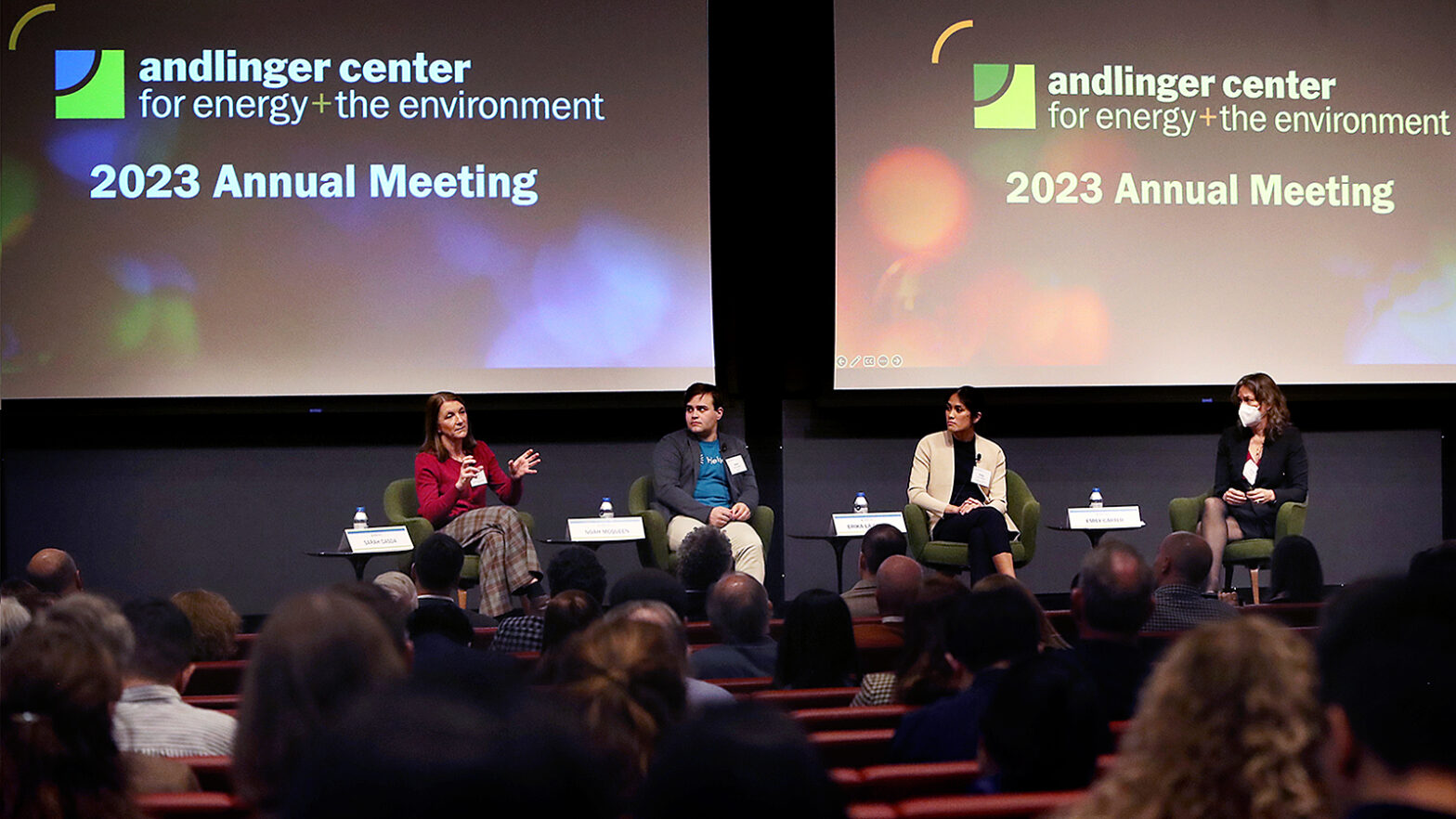 Four people share a stage during a panel discussion.