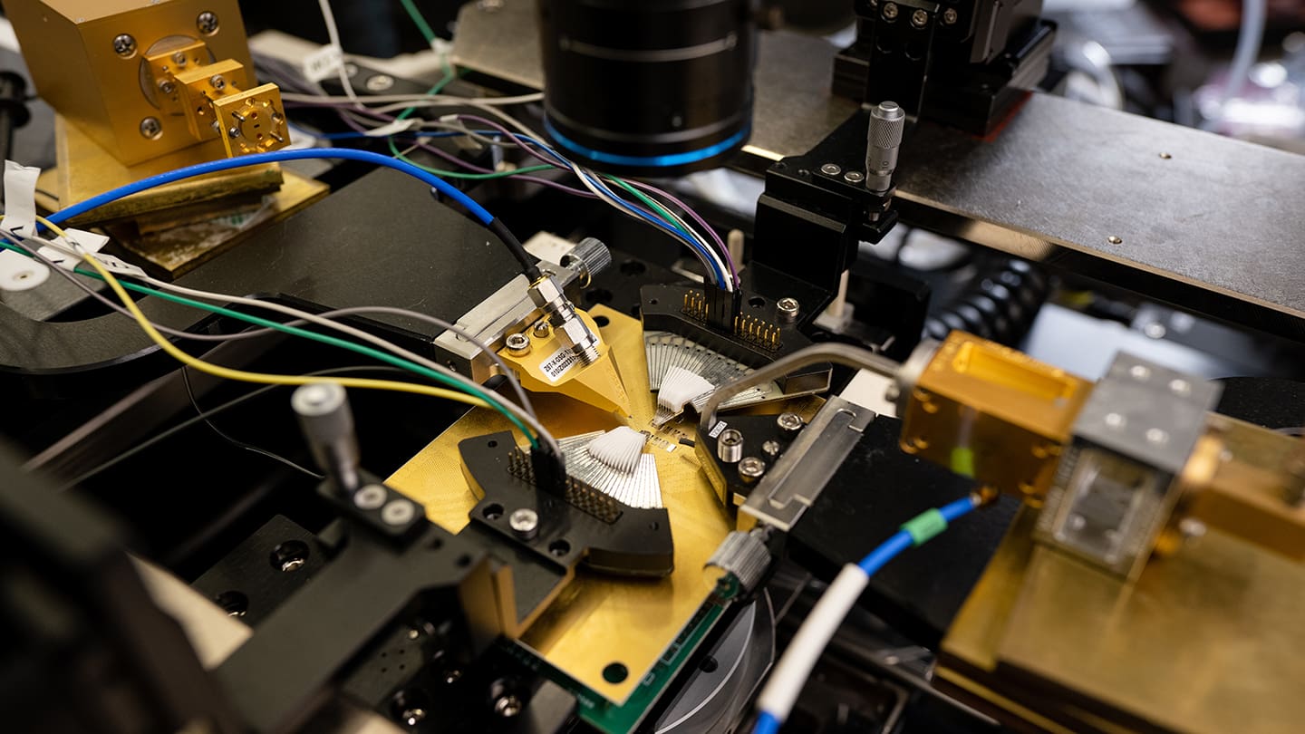Experimental technology setup with gold-plated devices, wires and a microscope.