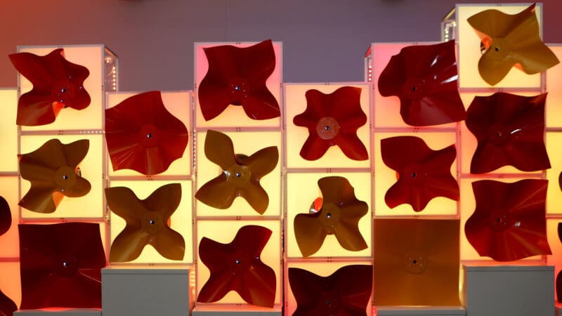 Colorful wall of robotic flowers, backlit.