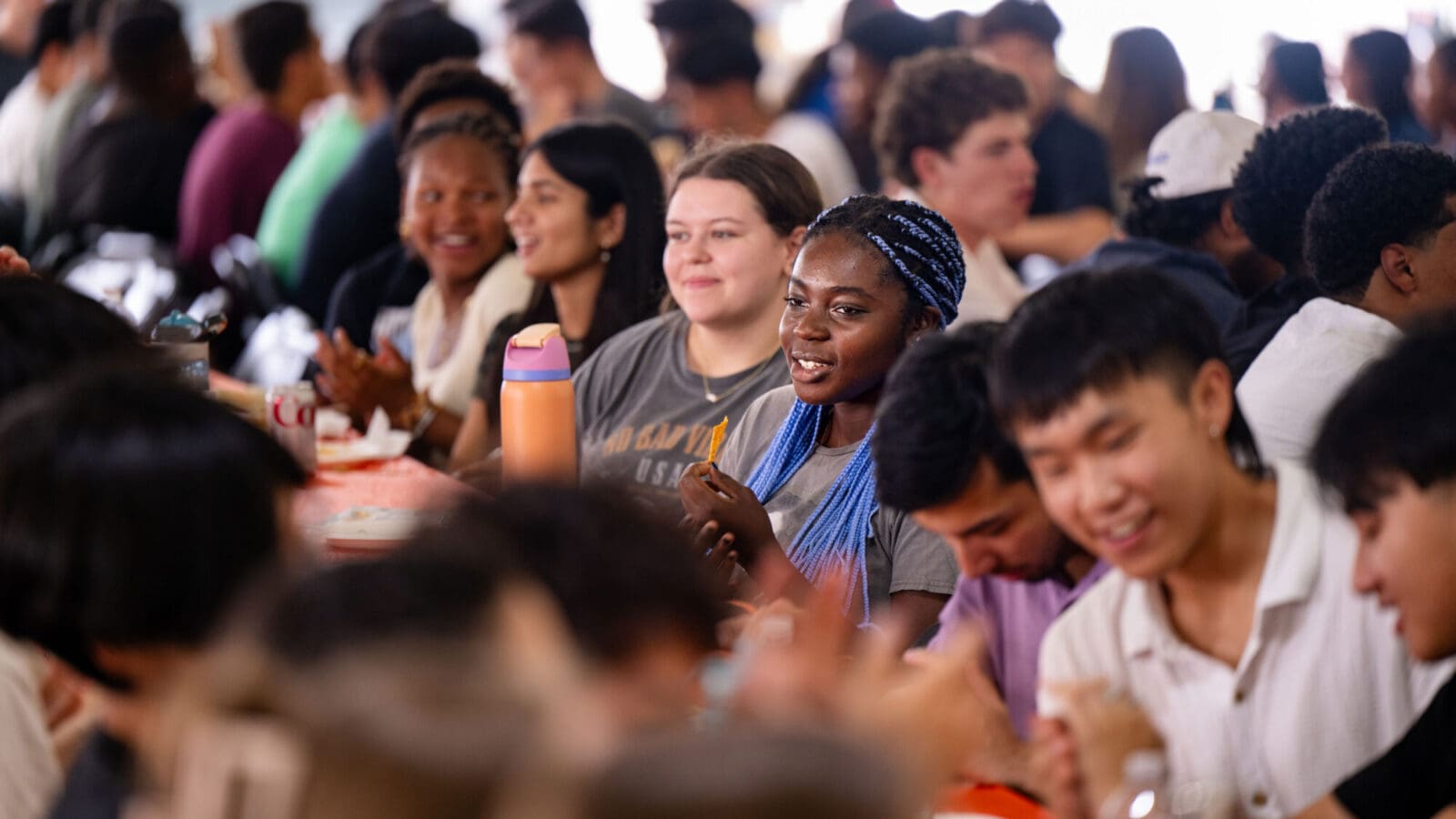 Students seated at a long table at the welcome lunch.