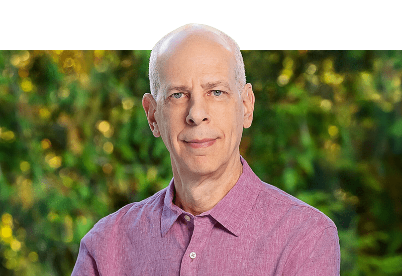 Man with white hair in a pink button down shirt