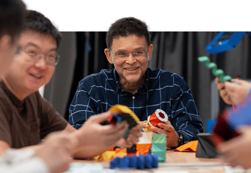 A group around a table holding cardboard figures folded in origami patterns