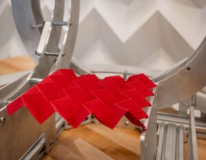 A sheet of red paper folded into alternating triangular hills and valleys