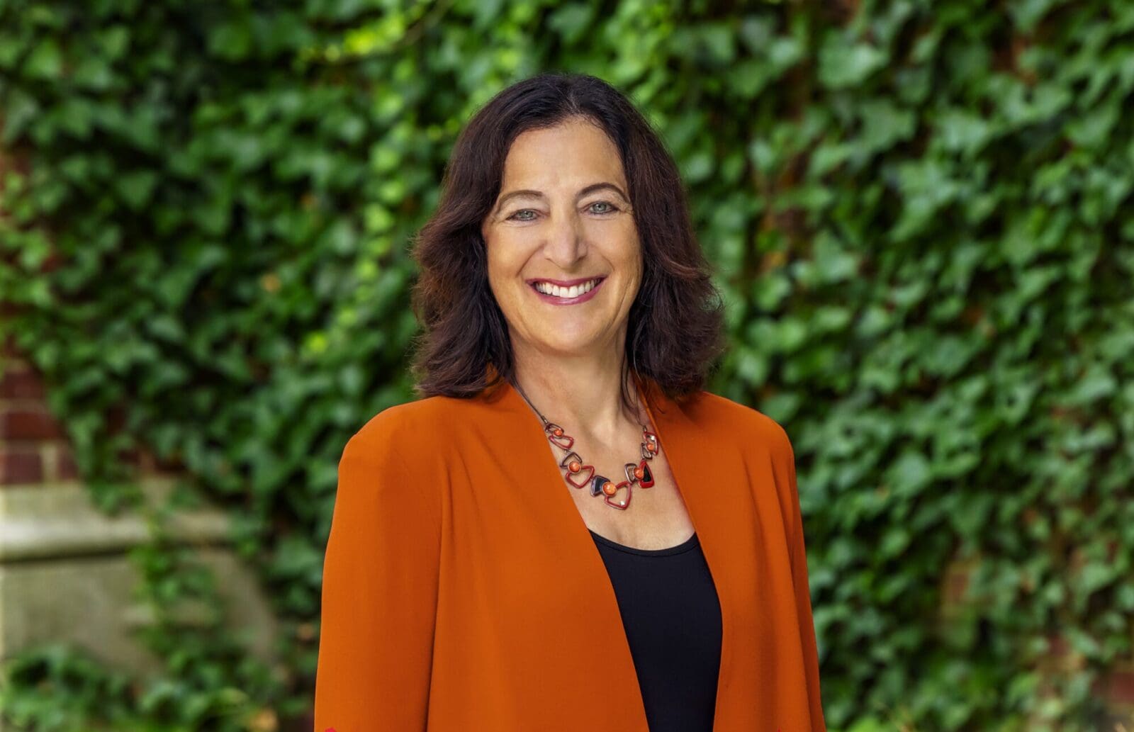 Dean Andrea Goldsmith wearing an orange blazer.