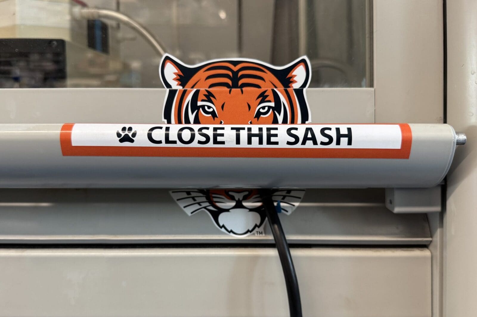 A tiger sticker with the words "Close the Sash."