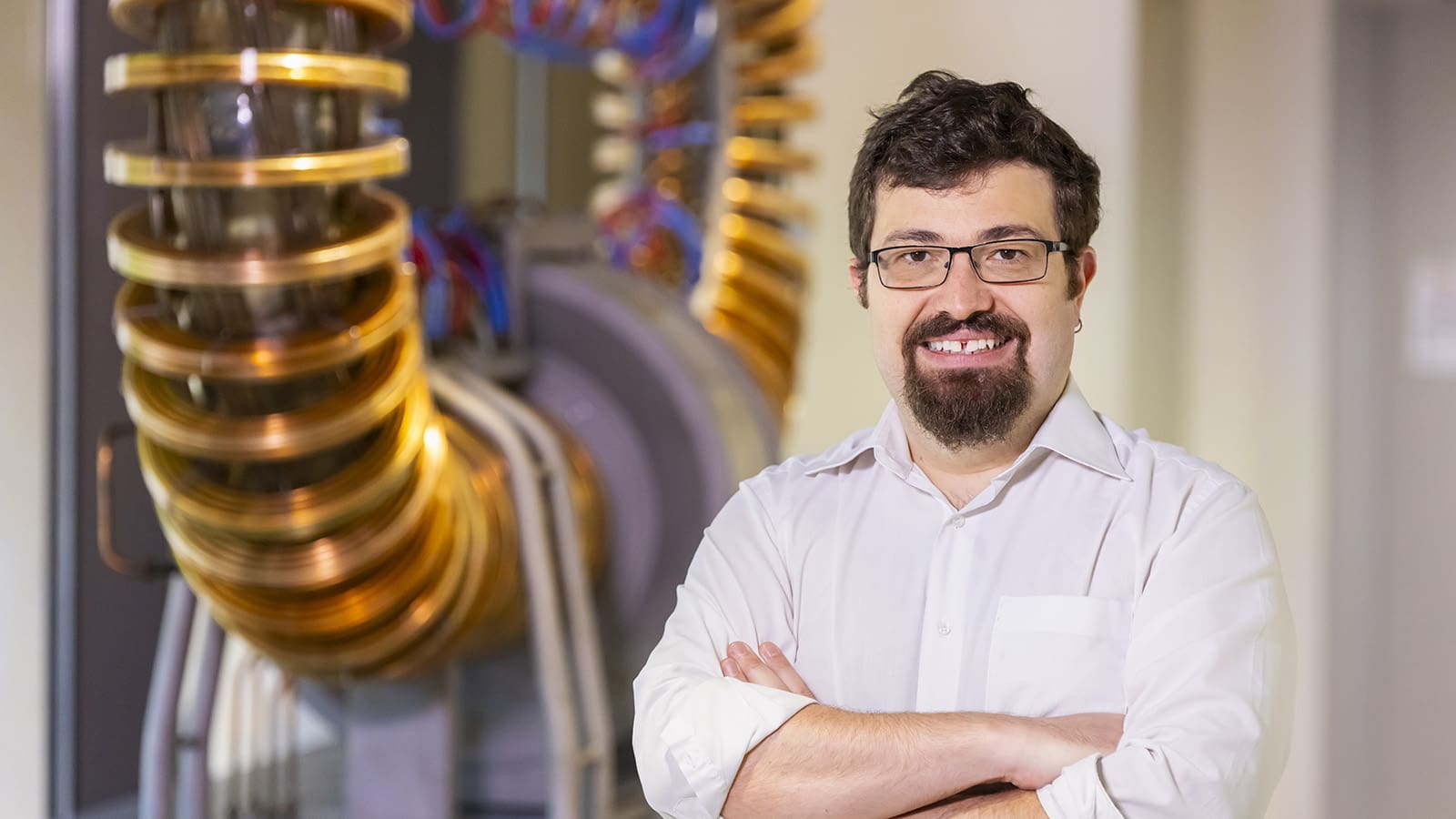 Portrait of man in front of machinery with large metal coils.