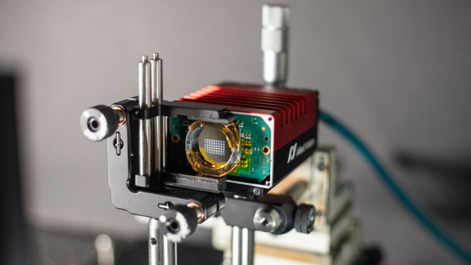 Close-up of optical device in lab showing 9x6 grid of small squares on a lens.