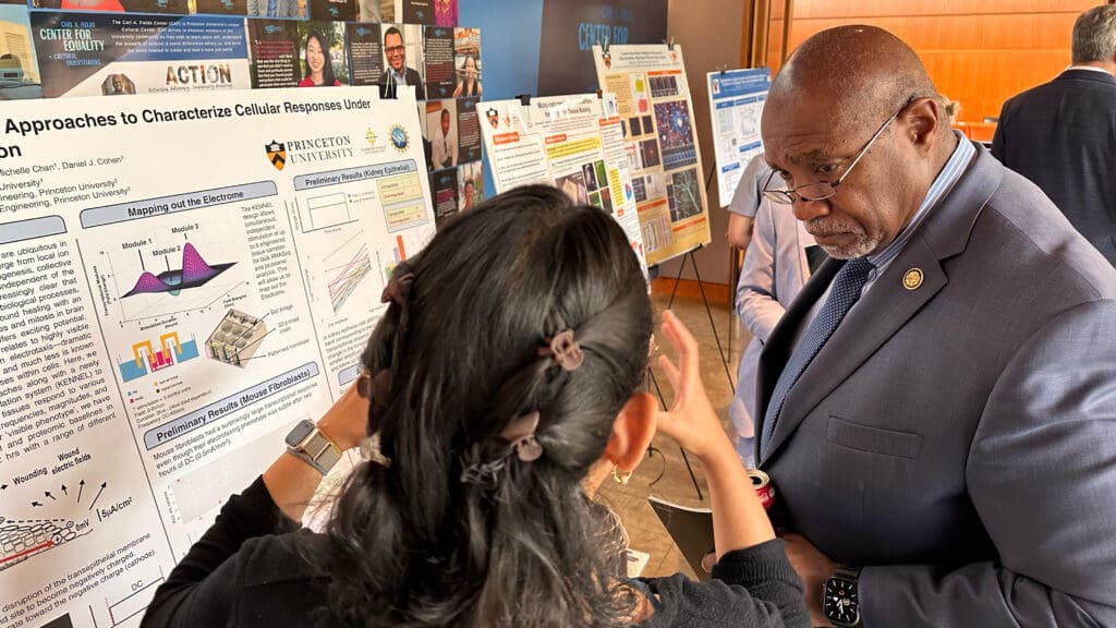 Man listens to graduate student speaking about her research