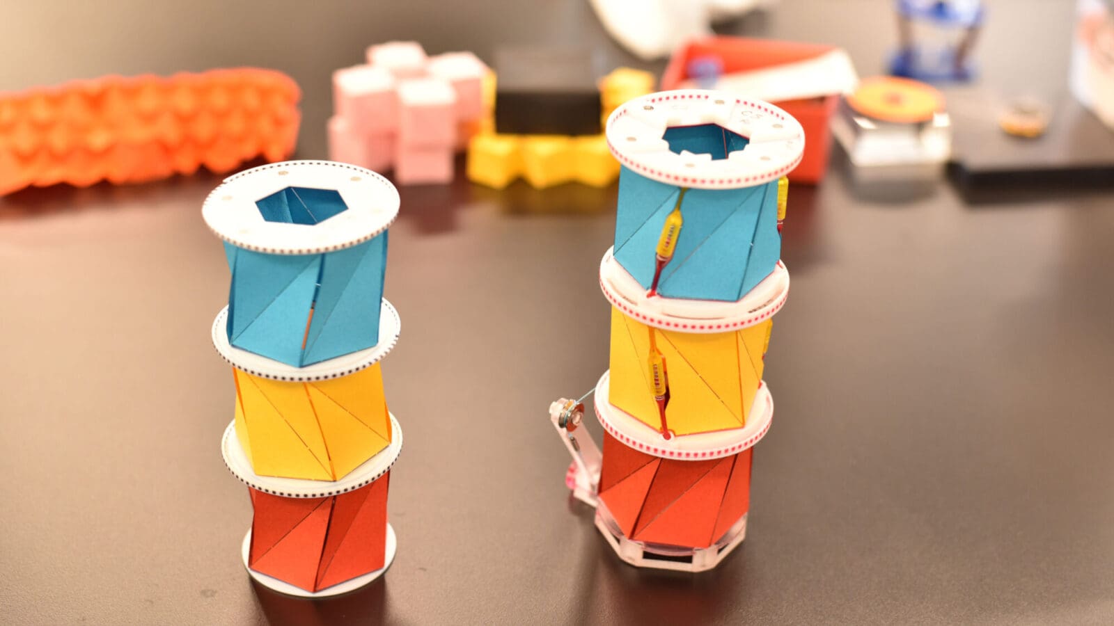 Multi-colored paper cylinders on a black lab table
