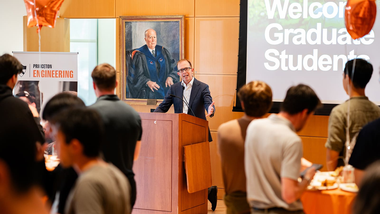 Dean speaks at podium in front of crowd of students.