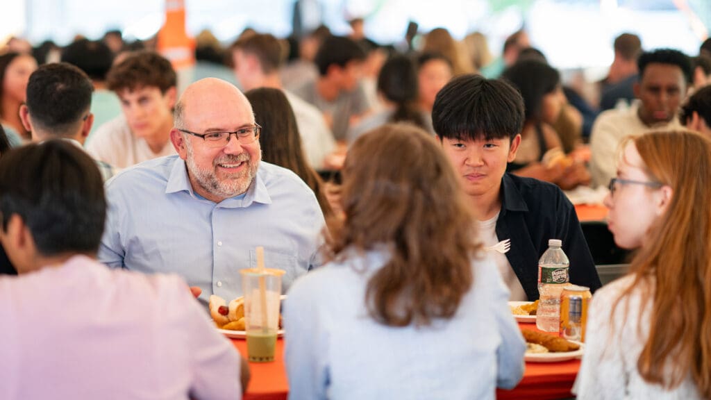 Individuals eating and socializing at a table.