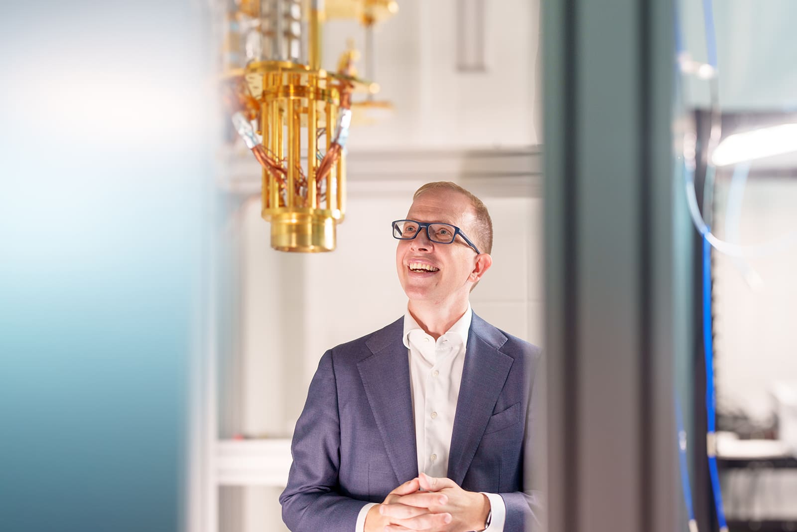 Andrew Houck looks up at the suspended chandelier of a superconducting quantum computer.
