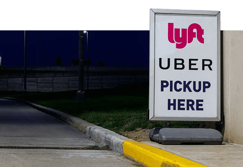 Uber and Lyft pick up here sign on a curb