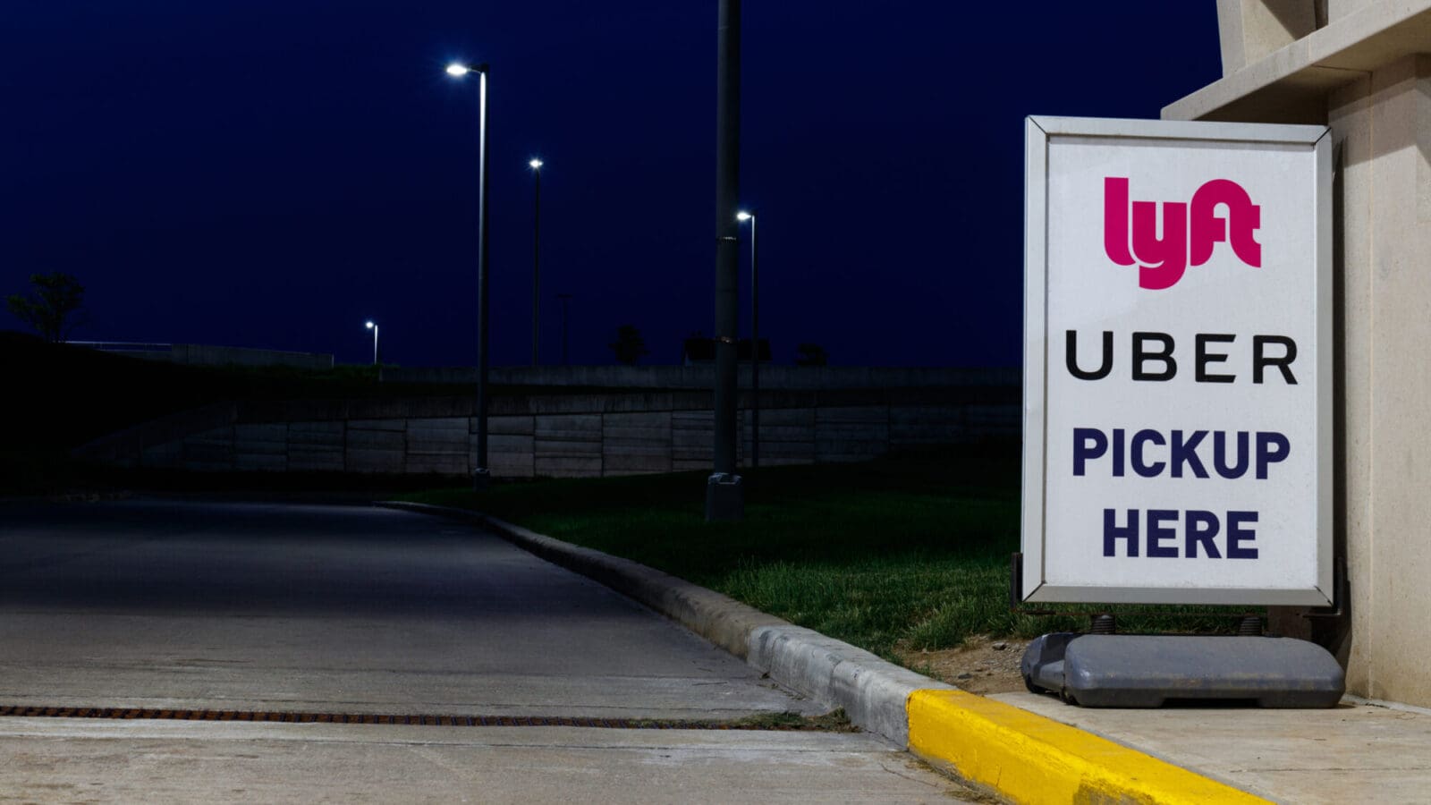 Uber and Lyft pick up here sign on a curb