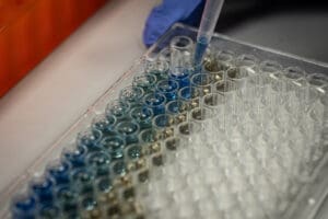 Pipette drawing liquid from one in an array of vials.