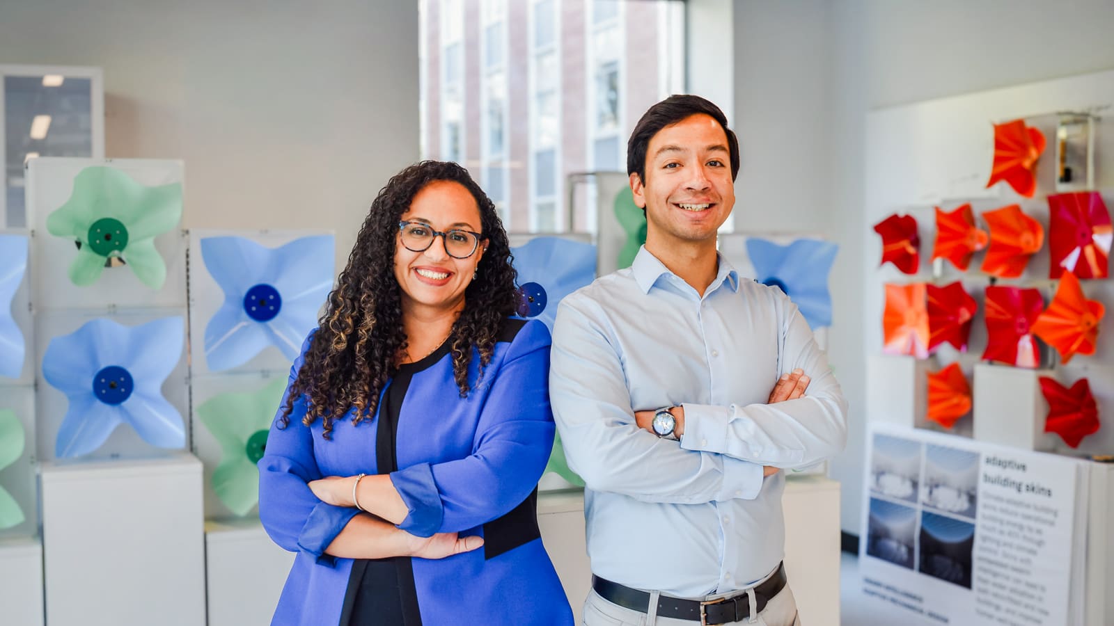 Aimy Wissa and Anirudha Majumdar posing with arms crossed in the robotics lab.