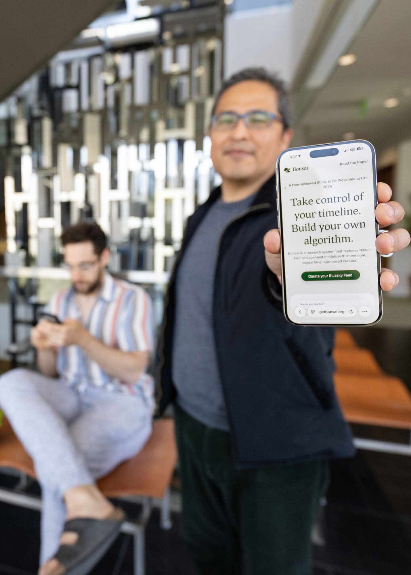 A man holding a phone up, with the words "Take control of your timeline. Build your own algorithm."