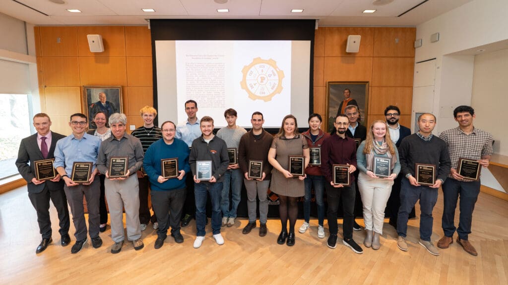 A group of people holding award plaques.