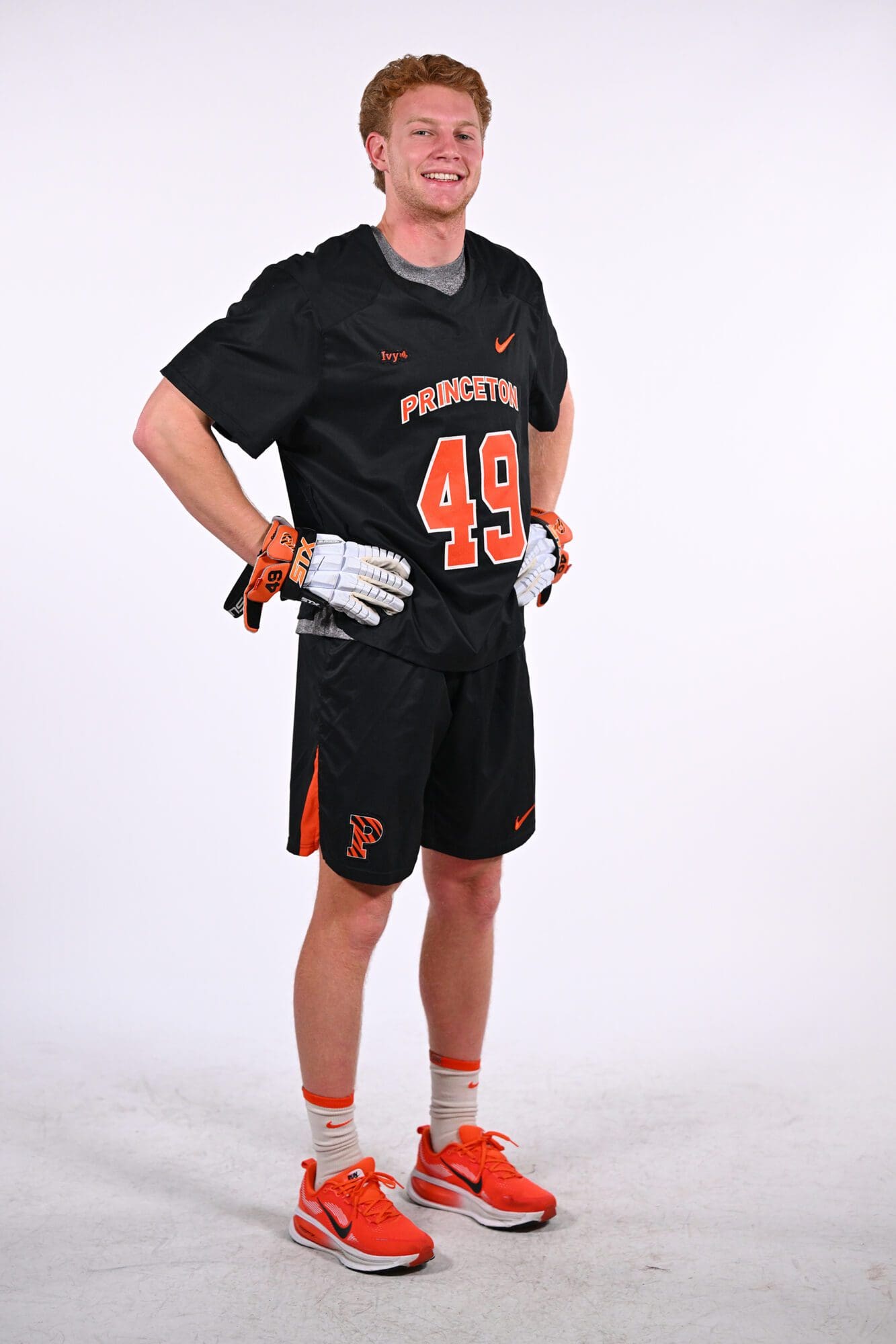 Full-length portrait of Tyler Harris in his lacrosse uniform, gloved hands on hips.