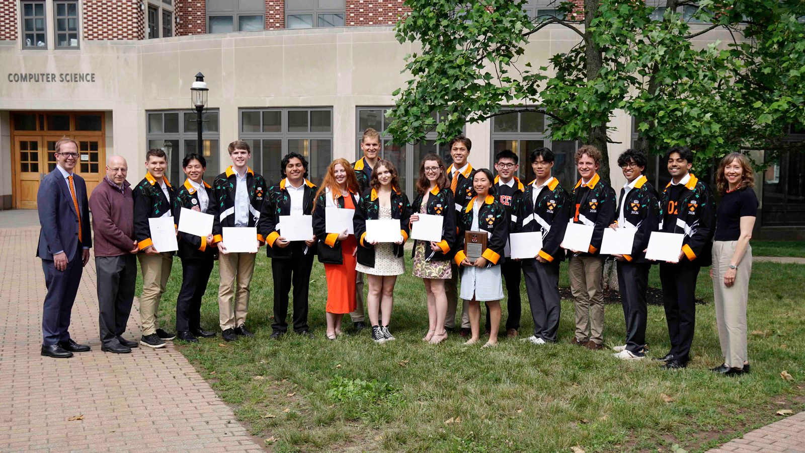 Line of award recipients holding their citations.