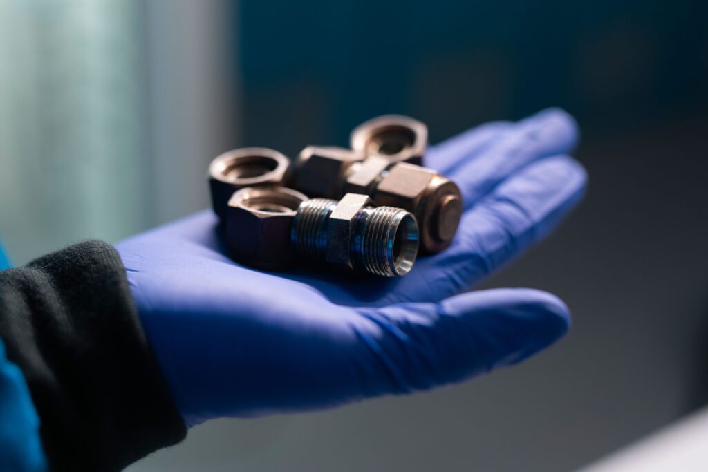 A close-up view of mini chemical reactors made from repurposed steel pipe connectors.