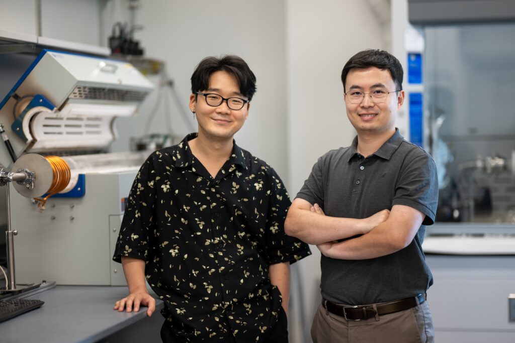 Jaehoon Ji and Saien Xie standing by a lab bench.