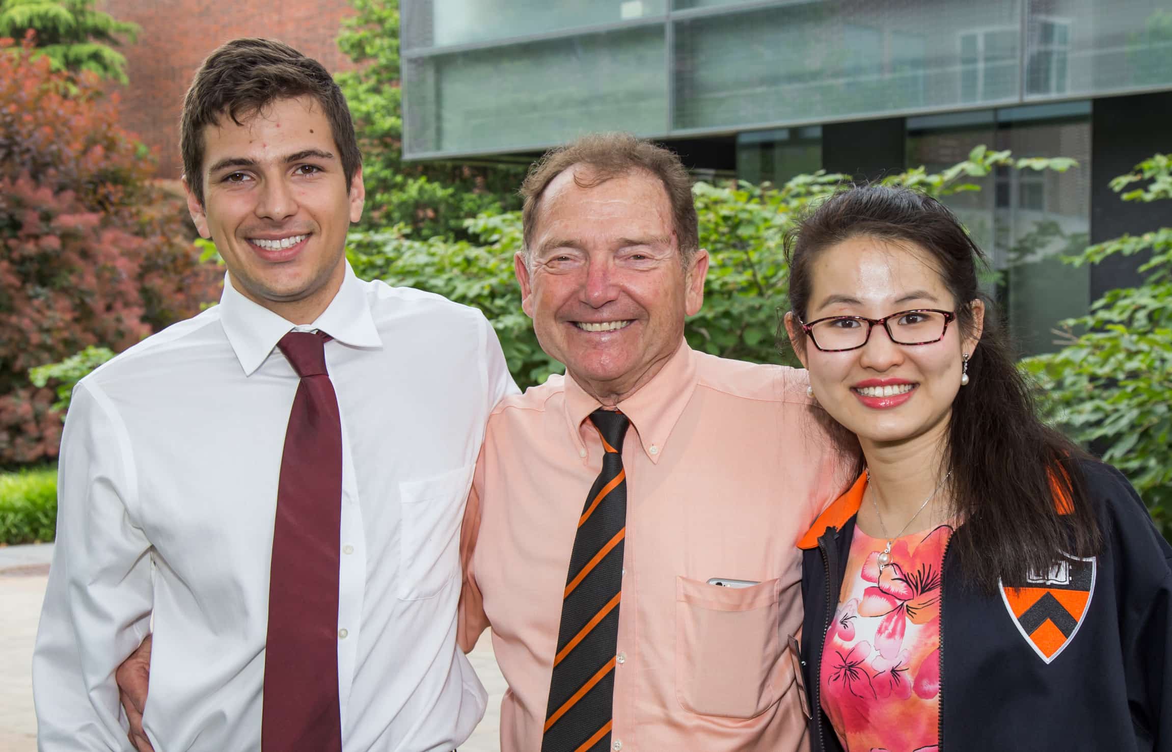 Alain Kornhauser, professor of operations research and financial engineering, congratulates Vladimir Feinberg and Lydia Liu, both of whom were among his freshman advisees four years ago. They are posing outdoors.