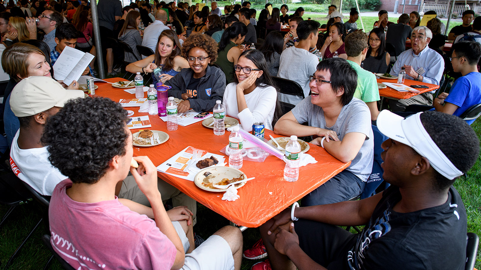 First-year undergraduates talk and eat at picnic table
