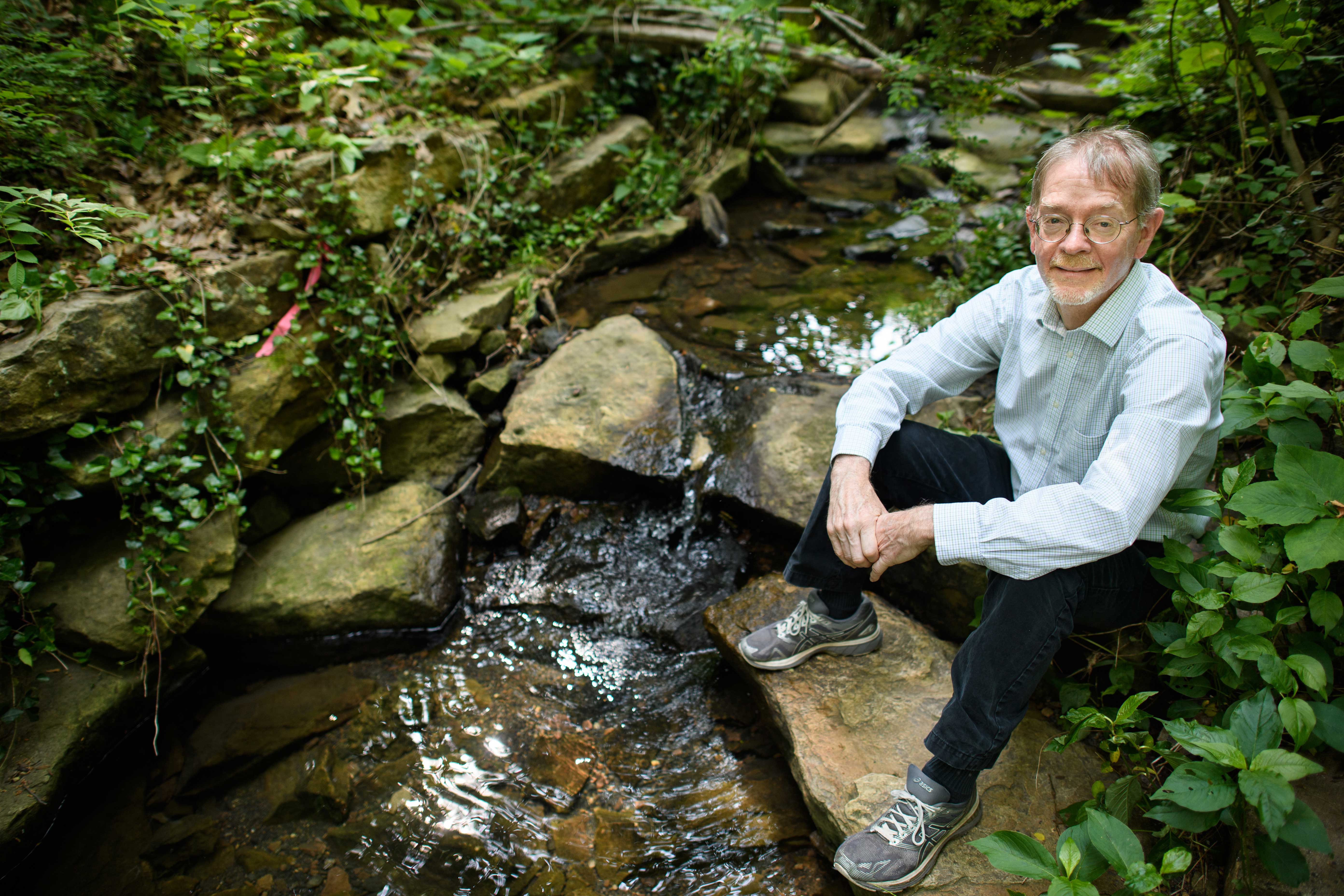 Researcher sitting on a streambank