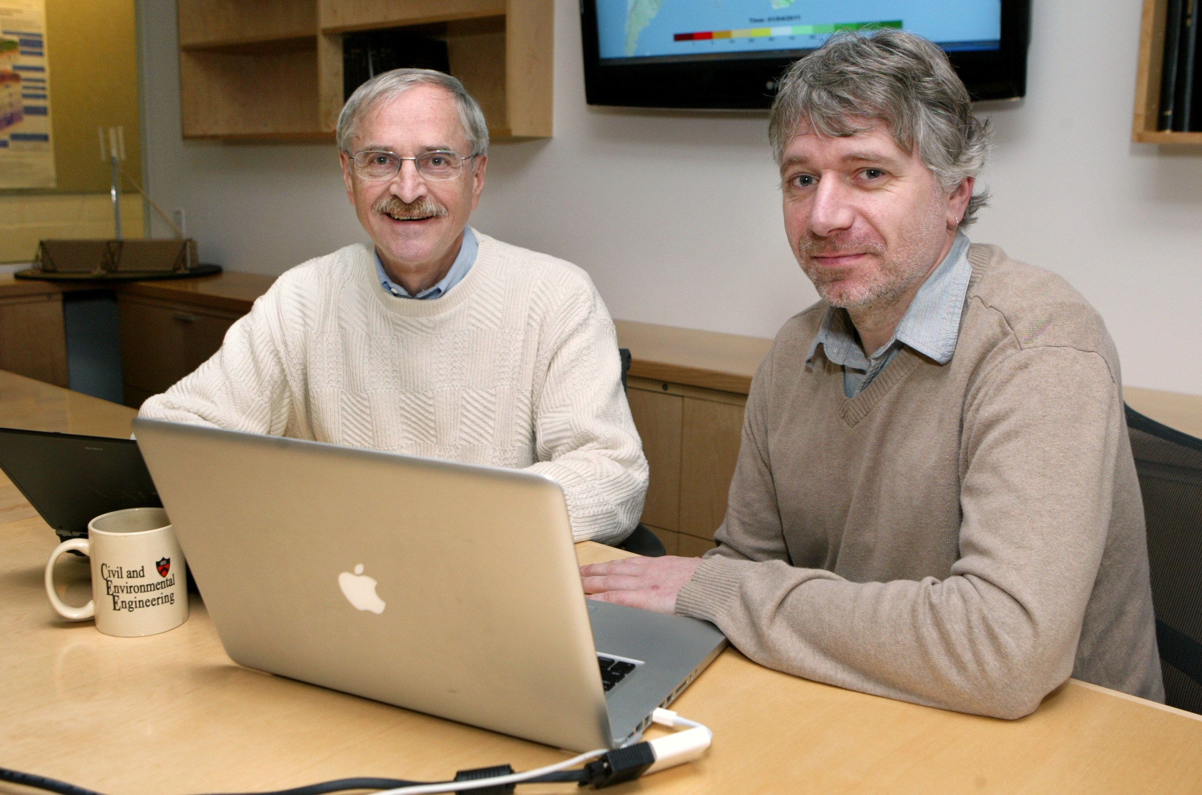 Two researchers working on a laptop