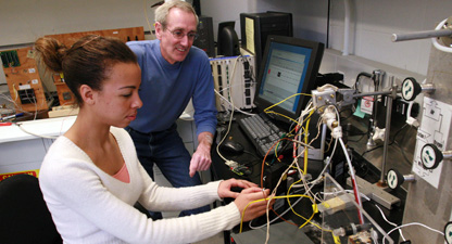 Professor Jay Benziger watches senior Tamara Whitaker adjust an experimental set-up