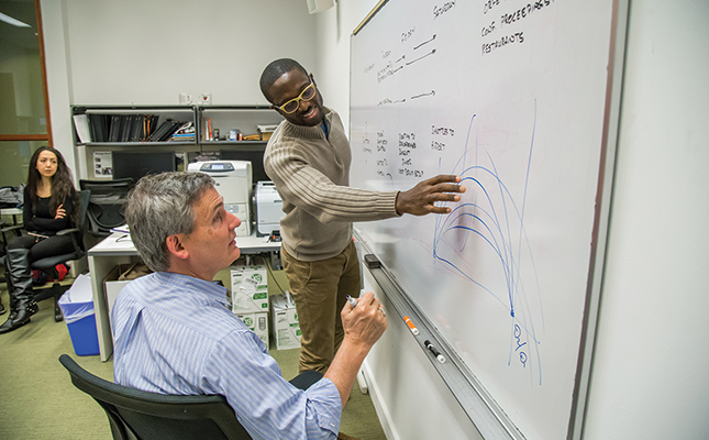 Warren Powell works with students by whiteboard
